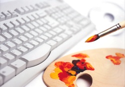 a paintbrush poised over a palette, with a keyboard sitting beside it