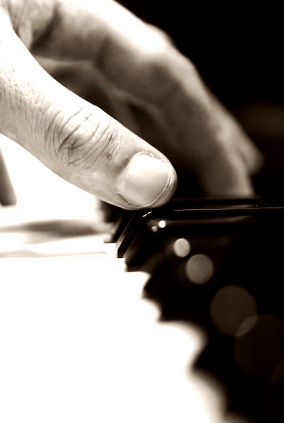 a man's hand playing the piano