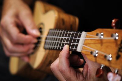 fingers on fret of a ukulele