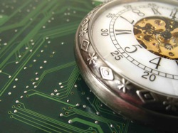 An antique pocket watch sitting on a circuitboard