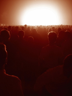 A crowd silhouetted by strong light
